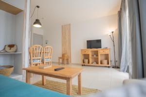 un soggiorno con tavolo e sedie in legno di Apartamentos Royal Life a Mahón