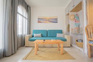 a living room with a blue couch and a table at Apartamentos Royal Life in Mahón
