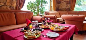 een tafel met een roze tafelkleed met voedsel erop bij Villa Kristiano 21 in Sarandë