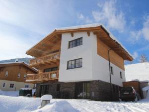 a house in the snow with a balcony at Modern chalet with sauna near ski area in Saalbach Hinterglemm Salzburgerland in Saalbach Hinterglemm