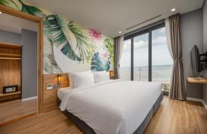 a bedroom with a large white bed and a large window at Flamingo Ibiza Hải Tiến in Nam Khê