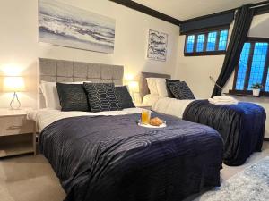 コルチェスターにあるDuchess Apt 1 Serviced 3BR Apartment in Colchester Perfect for Contractors,Temporary Housing, Relocations,Free Wifi, Secure Parkingの寝室にはベッドが2つあり、食事の皿も用意されている