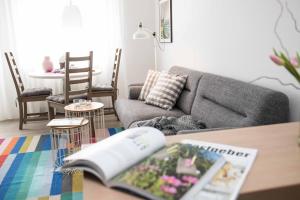 a living room with a couch and a book on a table at Appartementhaus Westend in Norderney +19 photos