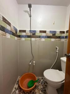 a bathroom with a toilet and a bowl with a shower at Bearbys Homestay Siargao - B in Catangnan