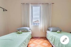 2 camas individuales en una habitación con ventana en Casa do Luis en São Paulo