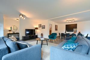 un salon avec des canapés bleus et une salle à manger dans l'établissement Villa contemporaine 7 minutes du Centre de Lille, à Marcq-en-Barœul