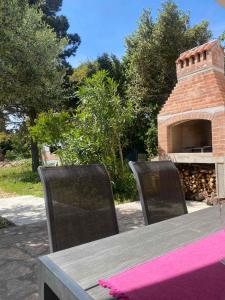 a table and two chairs with a brick oven at Apartments Silba in Silba
