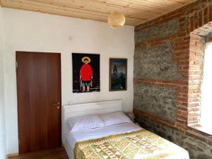 a bedroom with a bed and a brick wall at Old House in Lagodekhi