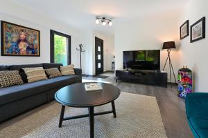 a living room with a couch and a table at Villa contemporaine 7 minutes du Centre de Lille in Marcq-en-Baroeul