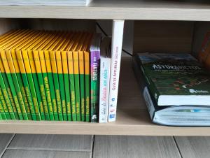 a group of books sitting on a book shelf at La Casa de Nuria in Cangas de Onís