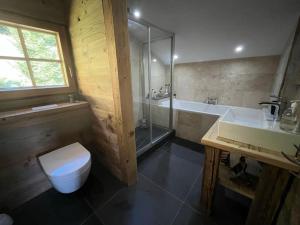 a bathroom with a toilet and a sink and a tub at Chalet Beaune - Charming and Stylish Chalet in Les Gets in Les Gets +38 photos