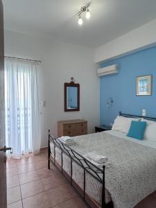 um quarto com uma cama com paredes azuis e um espelho em Sea-front Cozy Apartment em Elounda