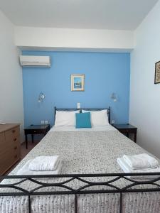 エロウンダにあるSea-front Cozy Apartmentの青い壁のベッドルーム1室(大型ベッド1台付)