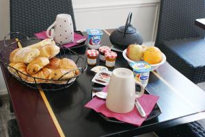 a table with a tray of bread and a basket of food at Hôtel Le Home Saint Louis in Versailles