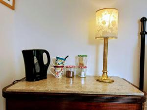 a table with a lamp and cups on it at Large Sunny King-Size En-Suite in Hastings +13 photos
