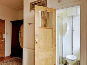 Large Sunny King-Size En-Suite في هاستينغز: حمام مع مرحاض وباب خشبي