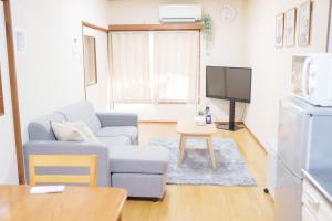 a living room with a couch and a tv at OK house2 住吉大社Available for up to 8 people in Osaka
