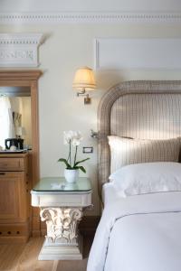 a bedroom with a bed and a table with flowers on it at Il Palazzetto in Rome +20 photos