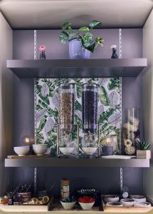 un estante con varios jarrones de cristal y plantas. en ibis Clermont Ferrand Sud Herbet en Clermont-Ferrand