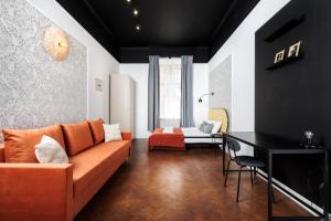 a living room with an orange couch and a table at Krupnicza Modern Old Town Apartments - by Upstairs in Kraków