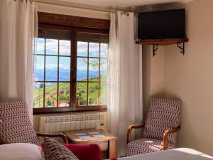 YusoにあるPosada Las Torresの椅子2脚と景色を望む窓が備わる客室です。
