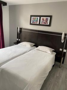 dos camas sentadas una al lado de la otra en un dormitorio en Hôtel Le Home Saint Louis, en Versalles