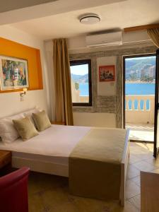 a bedroom with a bed with a view of the ocean at Hotel Kuč in Budva