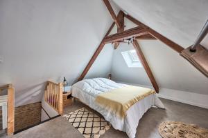une chambre avec un lit dans un grenier dans l'établissement La Maison du Pêcheur - A 250 m de la plage, à Saint-Aubin-sur-Mer