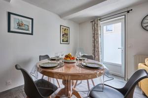 une salle à manger avec une table et des chaises et une fenêtre dans l'établissement La Maison du Pêcheur - A 250 m de la plage, à Saint-Aubin-sur-Mer 5 autres photos