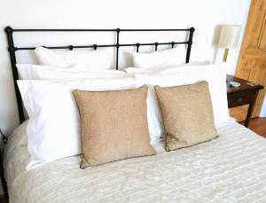 Large Sunny King-Size En-Suite في هاستينغز: سرير مع وسائد بيضاء وطاولة سوداء للرأس