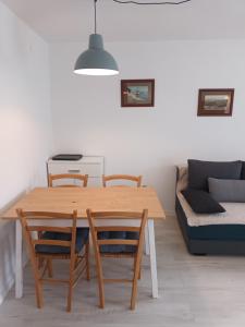 a dining room table with chairs and a couch at Apartments Dorcic in Baška