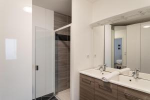 łazienka z 2 umywalkami i lustrem w obiekcie La Petite Enogatine - A moins d'un km de la plage w mieście Dinard