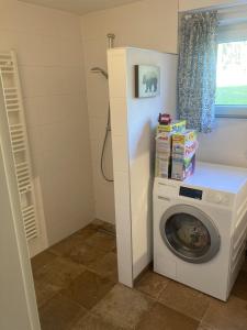 a laundry room with a washing machine and a window at Ferienwohnung am Waldrand mit Sauna in Biendorf