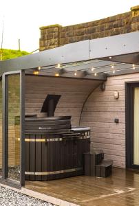 a barbecue grill on a patio of a house at Primrose Glamping Pods in Ingleton 