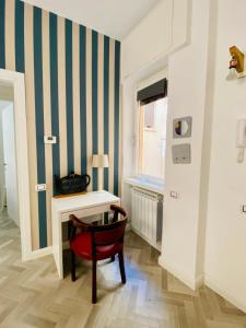 Habitación con escritorio y silla roja. en Pupazza House, intero appartamento nel cuore di Frascati, en Frascati