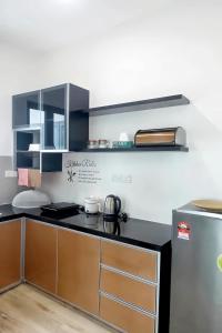 eine Küche mit einer schwarzen Arbeitsplatte und einem Kühlschrank in der Unterkunft Meritus Residensi Penang in Perai
