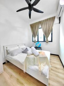 Schlafzimmer mit einem weißen Bett und einem Deckenventilator in der Unterkunft Meritus Residensi Penang in Perai