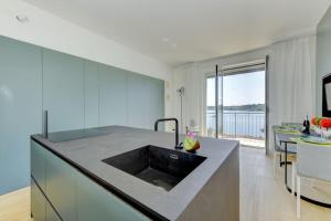 a kitchen with a large island with a sink at Blue Breeze Apartment in Salò