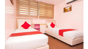 Duas camas com almofadas vermelhas num quarto em Bintang Square Hotel em Kubang Kerian