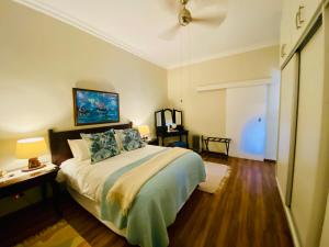 Schlafzimmer mit einem Bett, einem Schreibtisch und einem TV in der Unterkunft Rondeletia Cottage Guesthouse - premium self catering in Gillitts