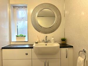 コルチェスターにあるDuchess Apt 1 Serviced 3BR Apartment in Colchester Perfect for Contractors,Temporary Housing, Relocations,Free Wifi, Secure Parkingの白い洗面台と鏡のあるバスルーム +24枚の写真