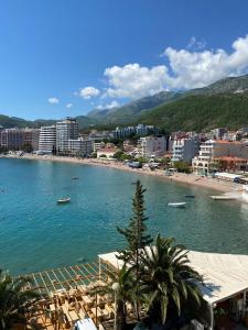 ein großer Wasserkörper mit Strand und Gebäuden in der Unterkunft Hotel Kuč in Budva