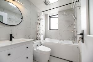 Hills&Coloured glaze Homestay في شانغهاي: حمام أبيض مع مرحاض بالوعة ومرآة