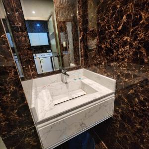 La salle de bains est pourvue d'un lavabo blanc et d'un miroir. dans l'établissement Blend Hotel, à Dammam
