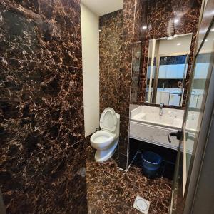 ein Badezimmer mit einem WC, einem Waschbecken und einem Spiegel in der Unterkunft Blend Hotel in Dammam
