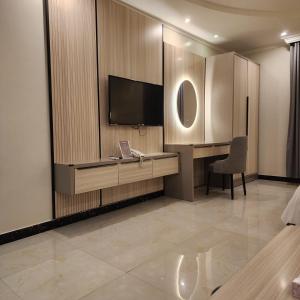 Zimmer mit einem Schreibtisch und einem TV in der Unterkunft Blend Hotel in Dammam