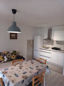 a kitchen and a table with a tablecloth on it at Apartments Dorcic in Baška