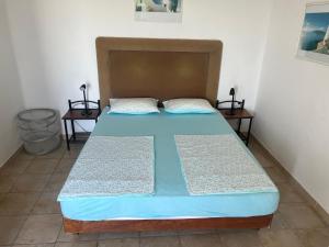 a bed in a room with two night stands at Eleni's Apartments in Agios Nikolaos