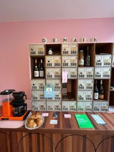 a counter with a shelf with bottles of wine at DEMAIN Hôtel & Conciergerie in Nantes