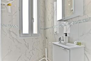 Baño blanco con lavabo y espejo en Magnifique 2 pieces aux portes de Paris, en Gagny
